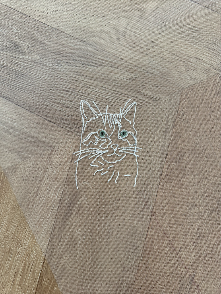 Portrait d'un chat brodé avec les yeux colorés sur un voile de mariée.