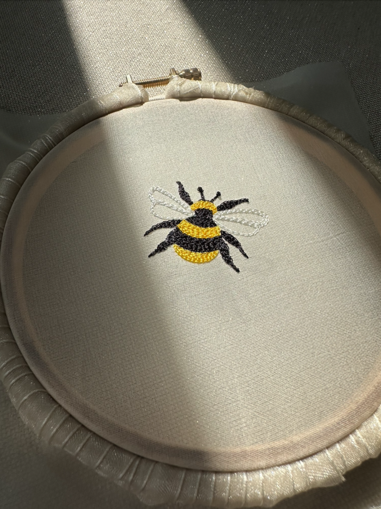 Broderie représentant une abeille réalisée à la main sur un voile de mariée.