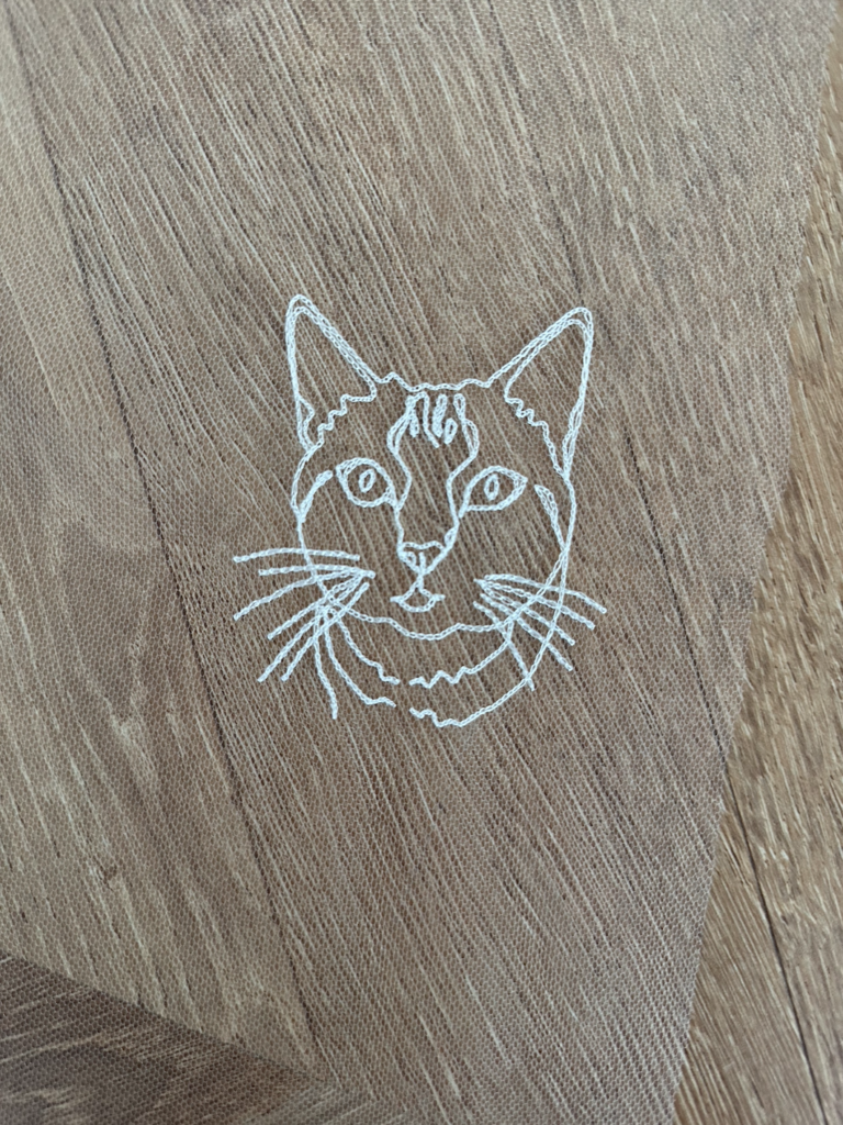 Portrait brodé d'un chat réalisé sur un voile de mariée en tulle.
