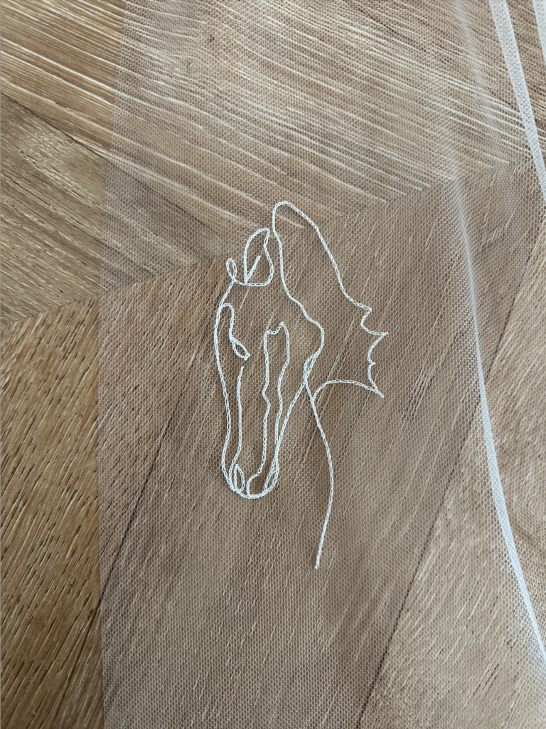 Portrait brodé d'un cheval réalisé sur un voile de mariée en tulle