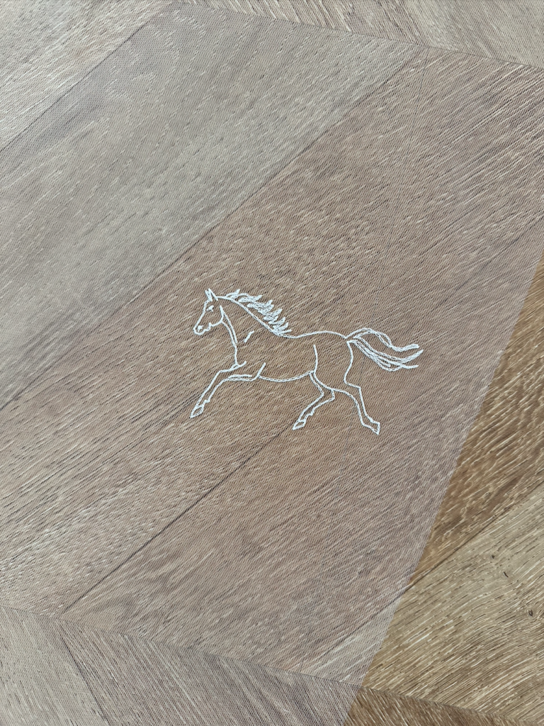 Cheval au galop brodé sur un voile de mariée en tulle.