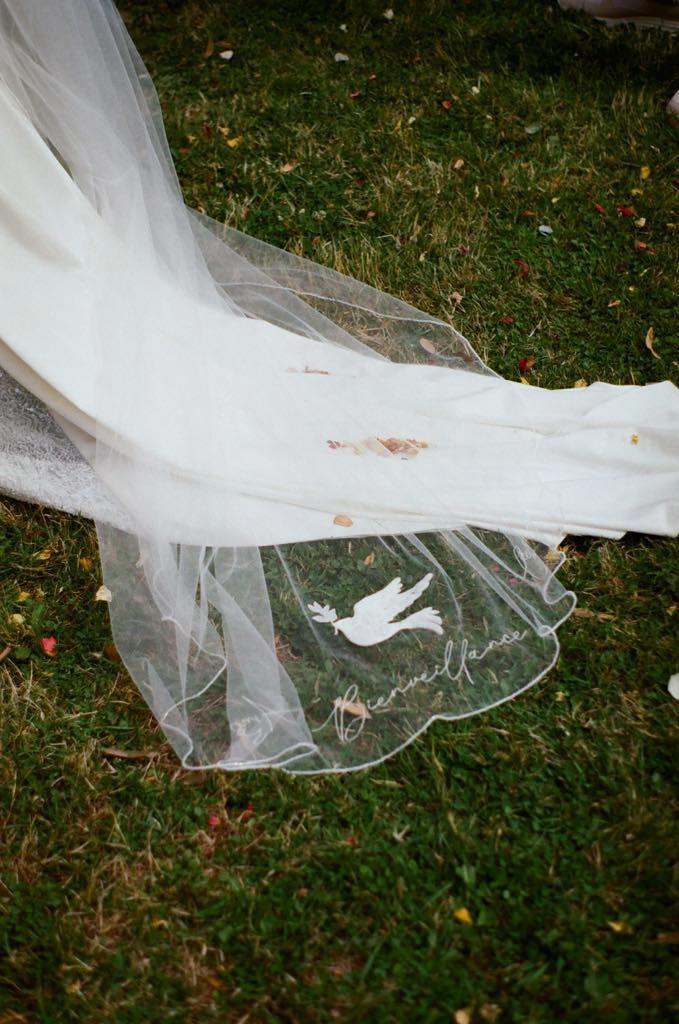 Voile de mariée personnalisé avec une colombe brodée et une signature brodée sur l'extrémité du tulle.