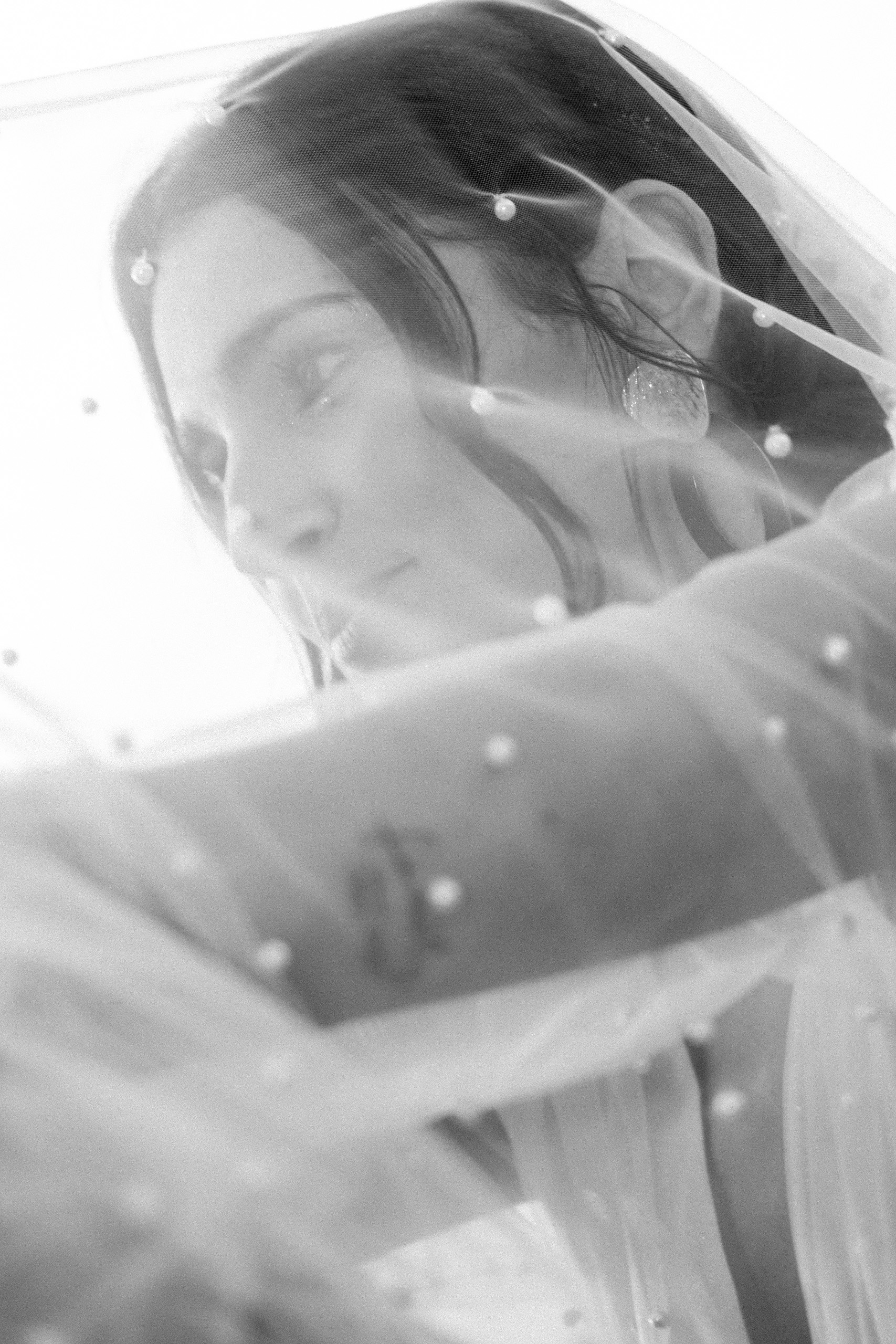 Portrait de mariée sous un voile de tulle parsemé de perles