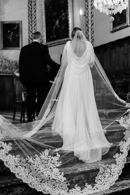 Mariée portant un voile cathédrale bordé de dentelle lors d'une cérémonie de mariage