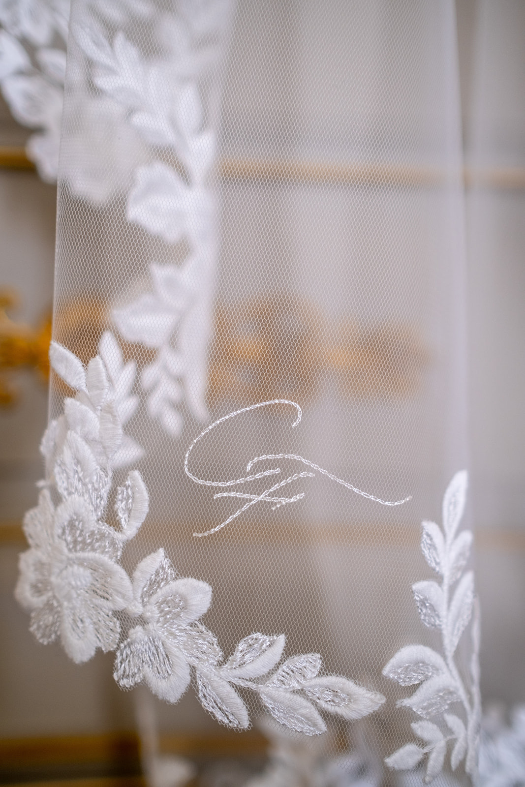 Détail d’un voile en dentelle avec initiales brodées à la main